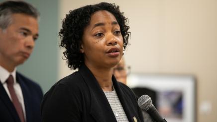 Image of Assemblymember Akilah Weber speaking at microphone.